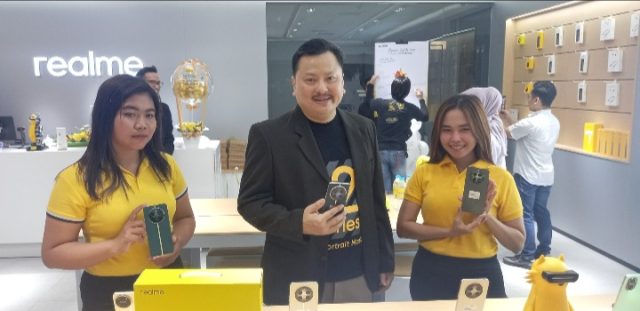 Rony Candra, owner Asia Jaya bersama sales memamerkan realme terbaru 12 series. (Foto: Adrian/ Kadenews.com)